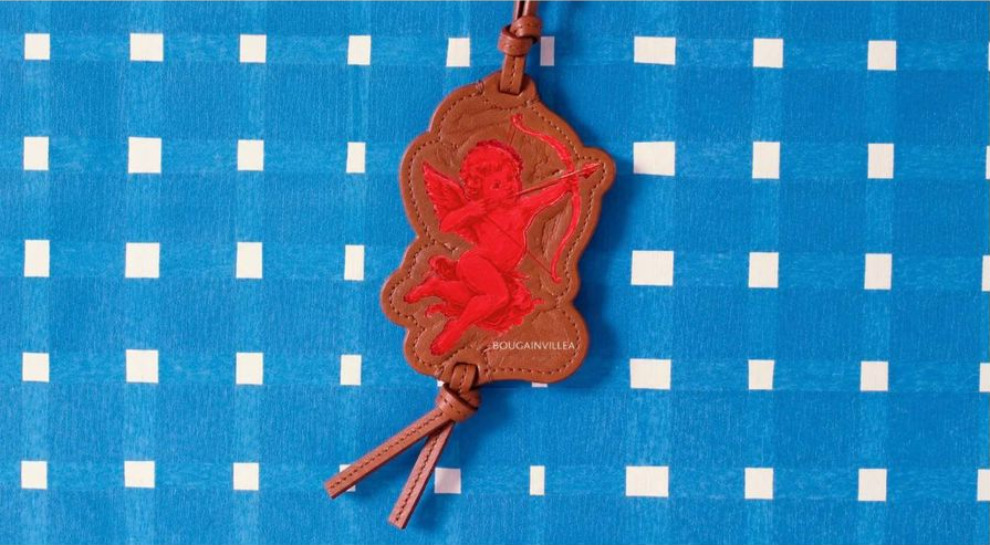 Bougainvillea Cupid leather tag on blue fabric